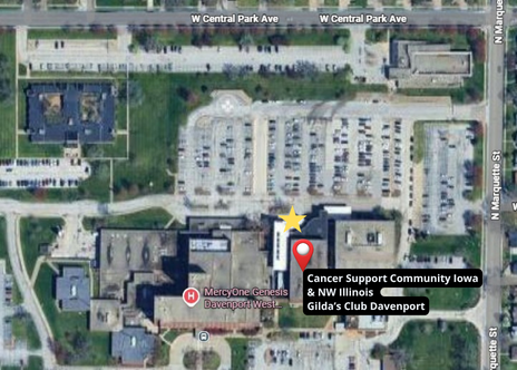 Satellite view of Cancer Support Community Iowa & NW Illinois Gilda’s Club Davenport. A red location pin and a yellow star mark the specific facility situated next to the MercyOne Genesis Davenport West hospital. The location is bordered by large parking lots, with West Central Park Ave to the north and North Marquette St to the east.
